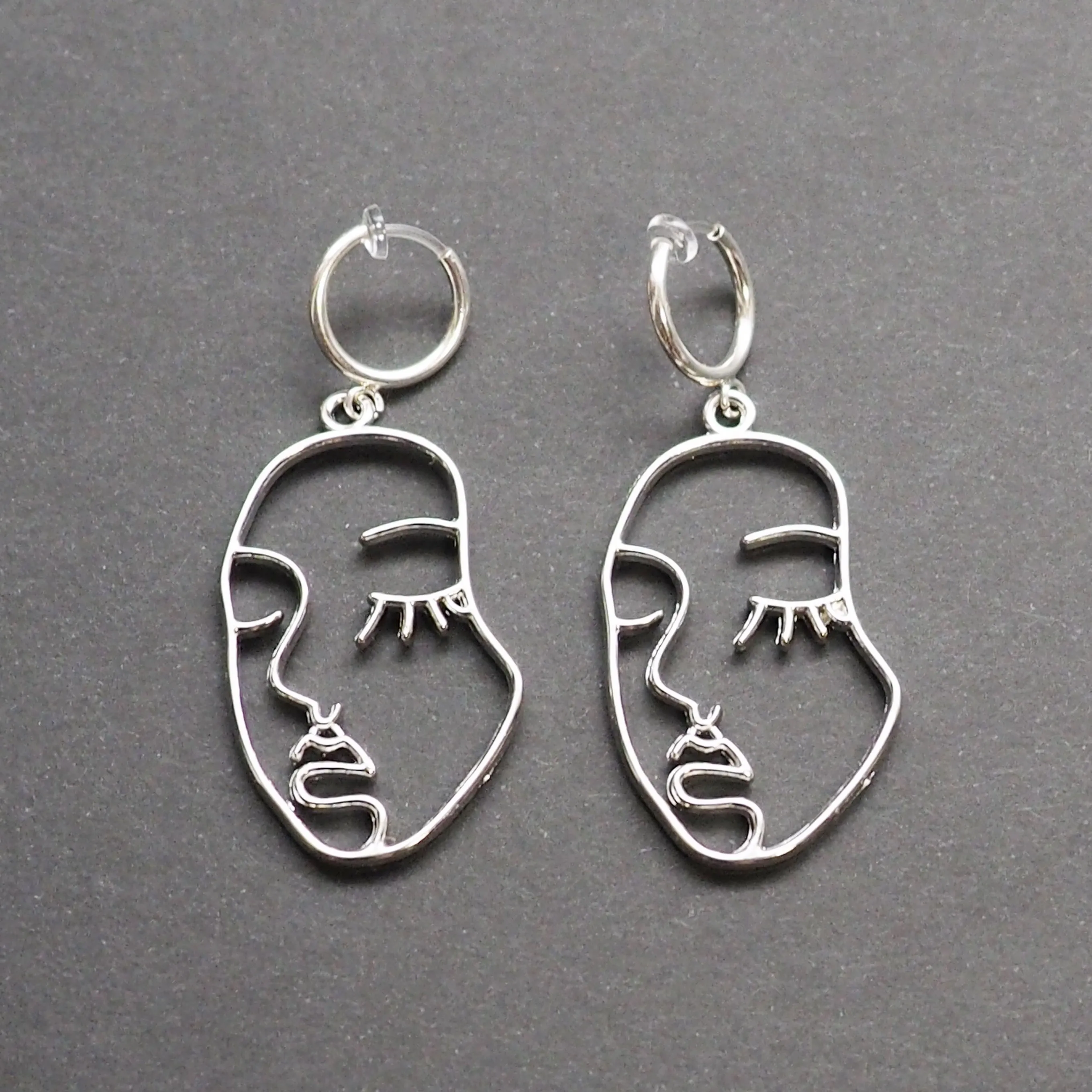 Silver human face clip on hoop earrings